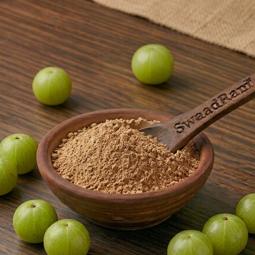 A close-up shot showing the authentic, fine texture of raw organic sundried amla powder in a traditional brass spoon.