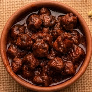 A close-up shot of an authentic jar of Swaadrani homemade boneless chicken pickle, showcasing rich spices and tender chicken pieces.
